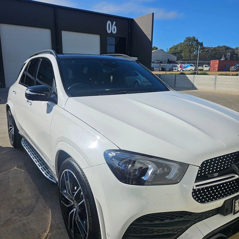 A White Car Is Parked In Front Of A Building With The Number 06 On It — On Point Detailing Wagga in East Wagga Wagga, NSW