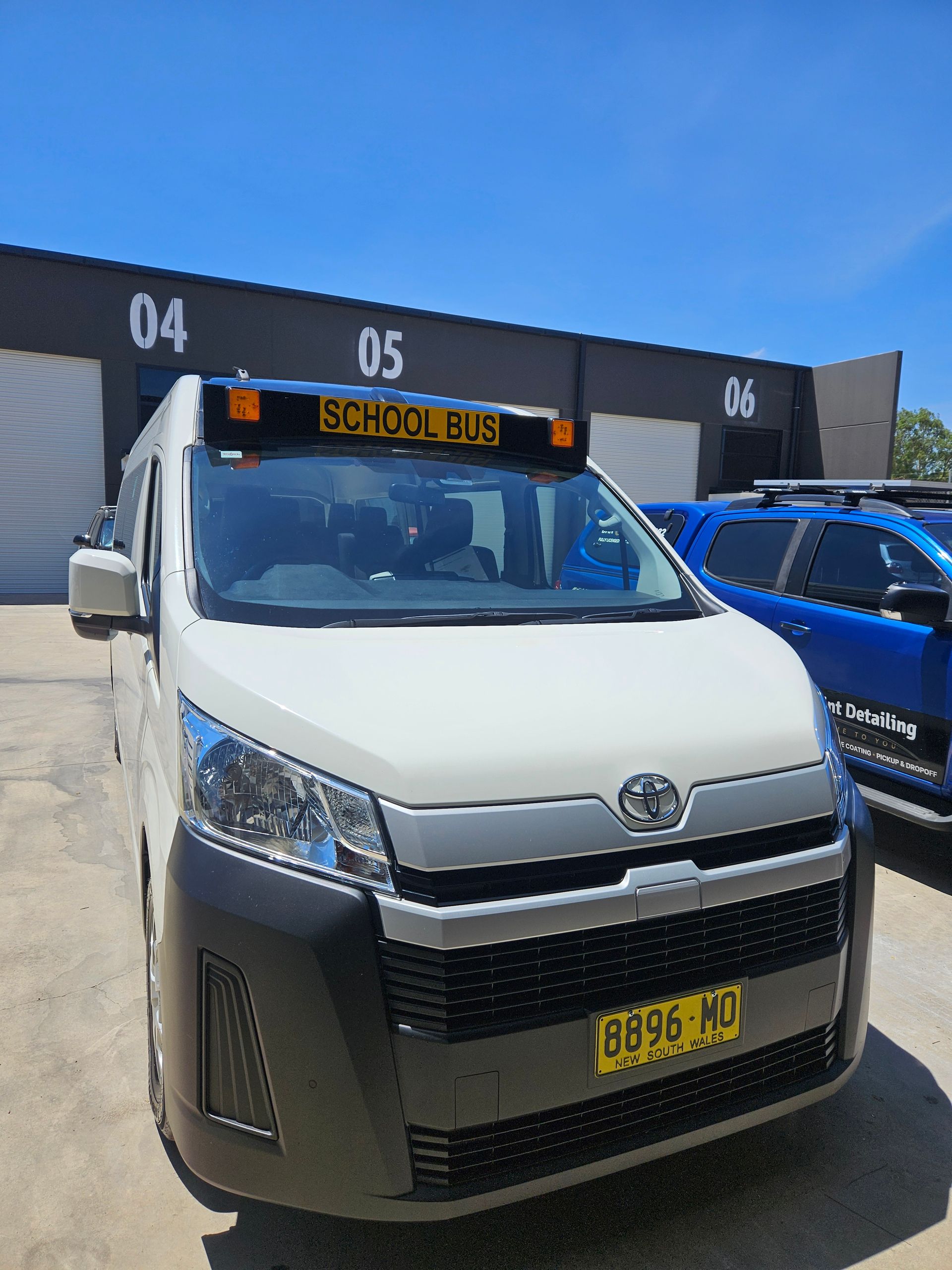 A White School Bus is Parked in Front of a Building — On Point Detailing Wagga in East Wagga Wagga, NSW