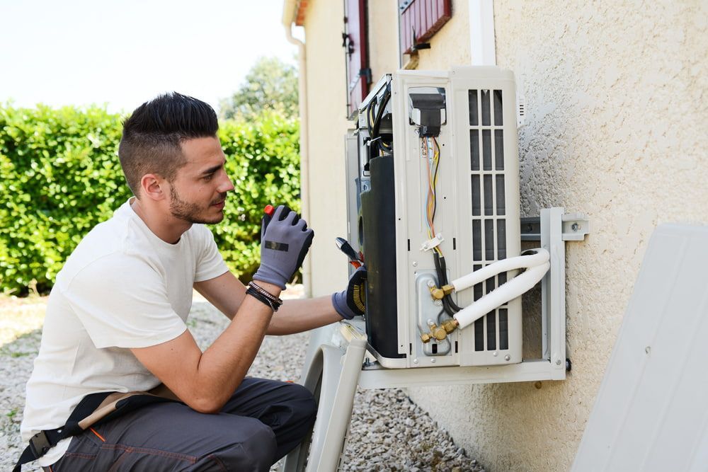 Man Repairing an Outdoor Air Conditioner — Hinterland Air Conditioning Sunshine Coast in Flaxton, QLD