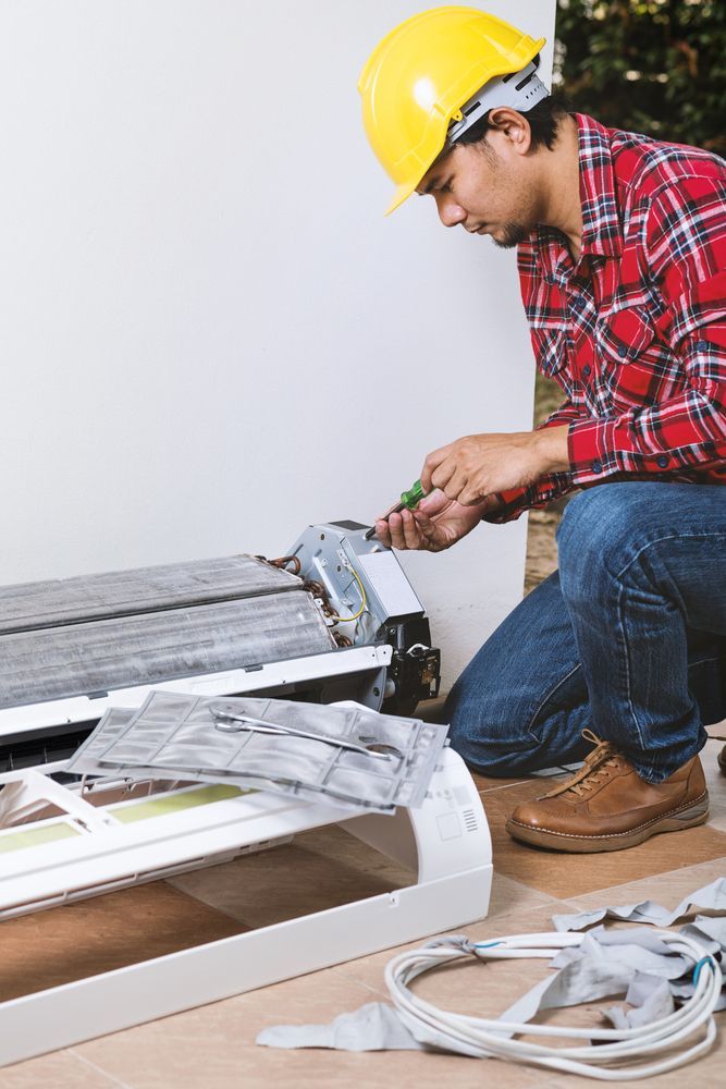 HVAC Technician Kneels to Service an Ac Unit — Hinterland Air Conditioning Sunshine Coast in Montville, QLD