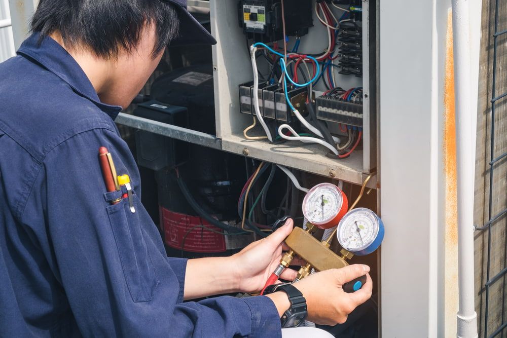 HVAC Technician Using Gauges to Check an Air Conditioning Unit — Hinterland Air Conditioning Sunshine Coast in Woombye, QLD