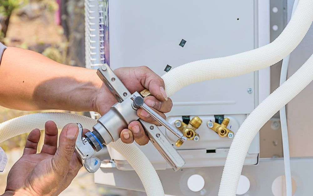 Person Using a Tool to Connect a Hose to an Air Conditioning Unit — Hinterland Air Conditioning Sunshine Coast in Eudlo, QLD