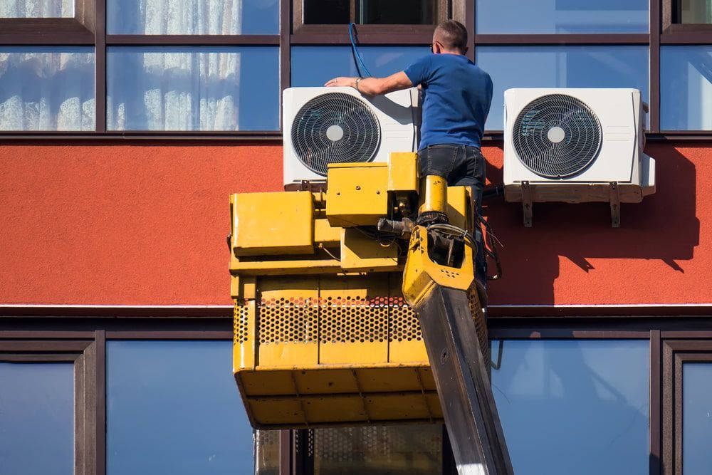 Man in a Lift Installs an Air Conditioning Unit — Hinterland Air Conditioning Sunshine Coast in Palmwoods, QLD