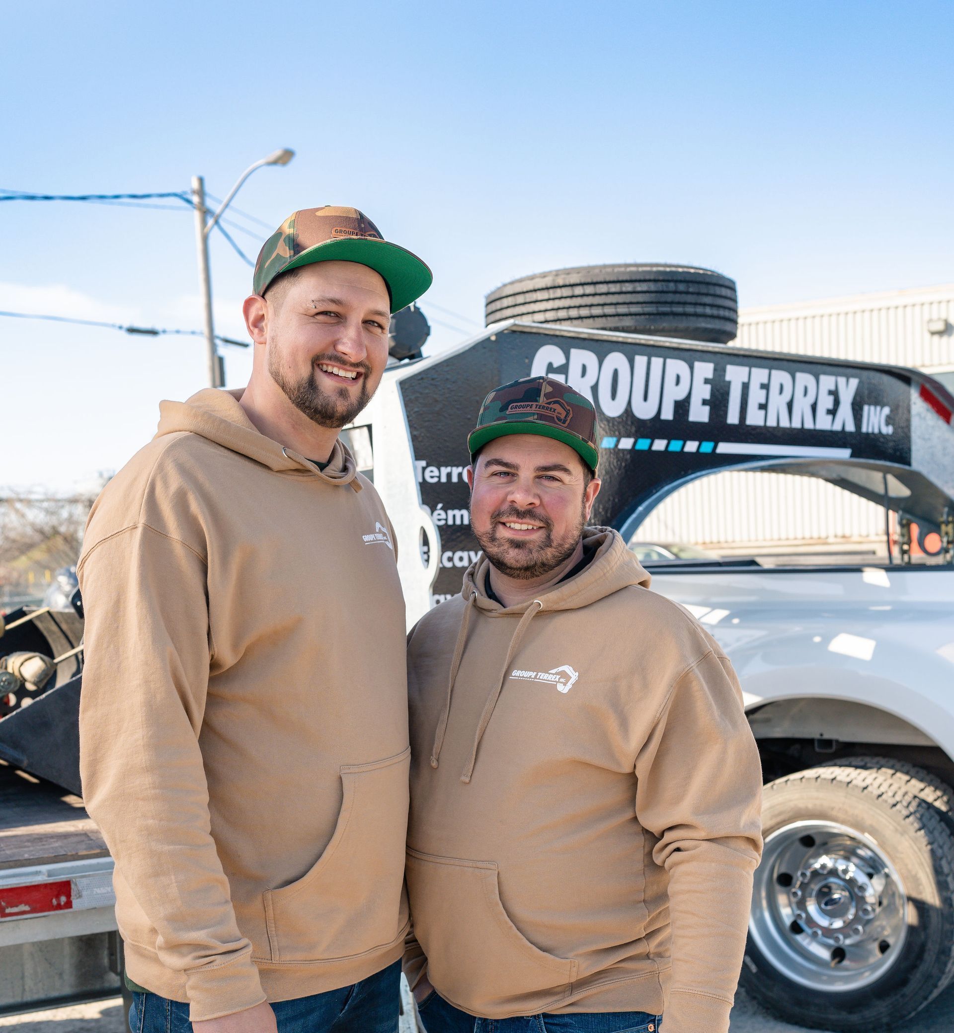 Deux hommes se tiennent côte à côte devant un camion.