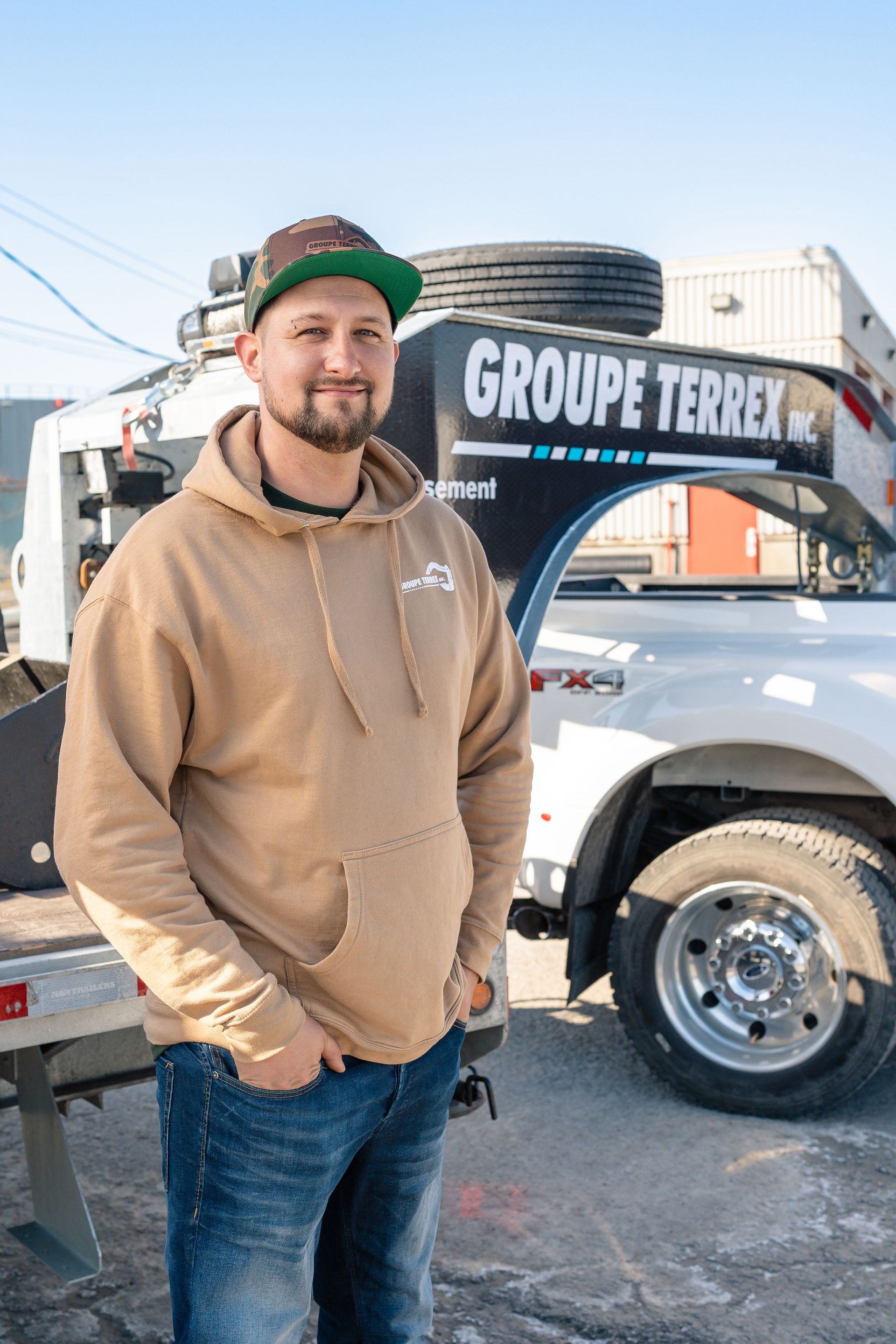 Un homme se tient devant une dépanneuse.