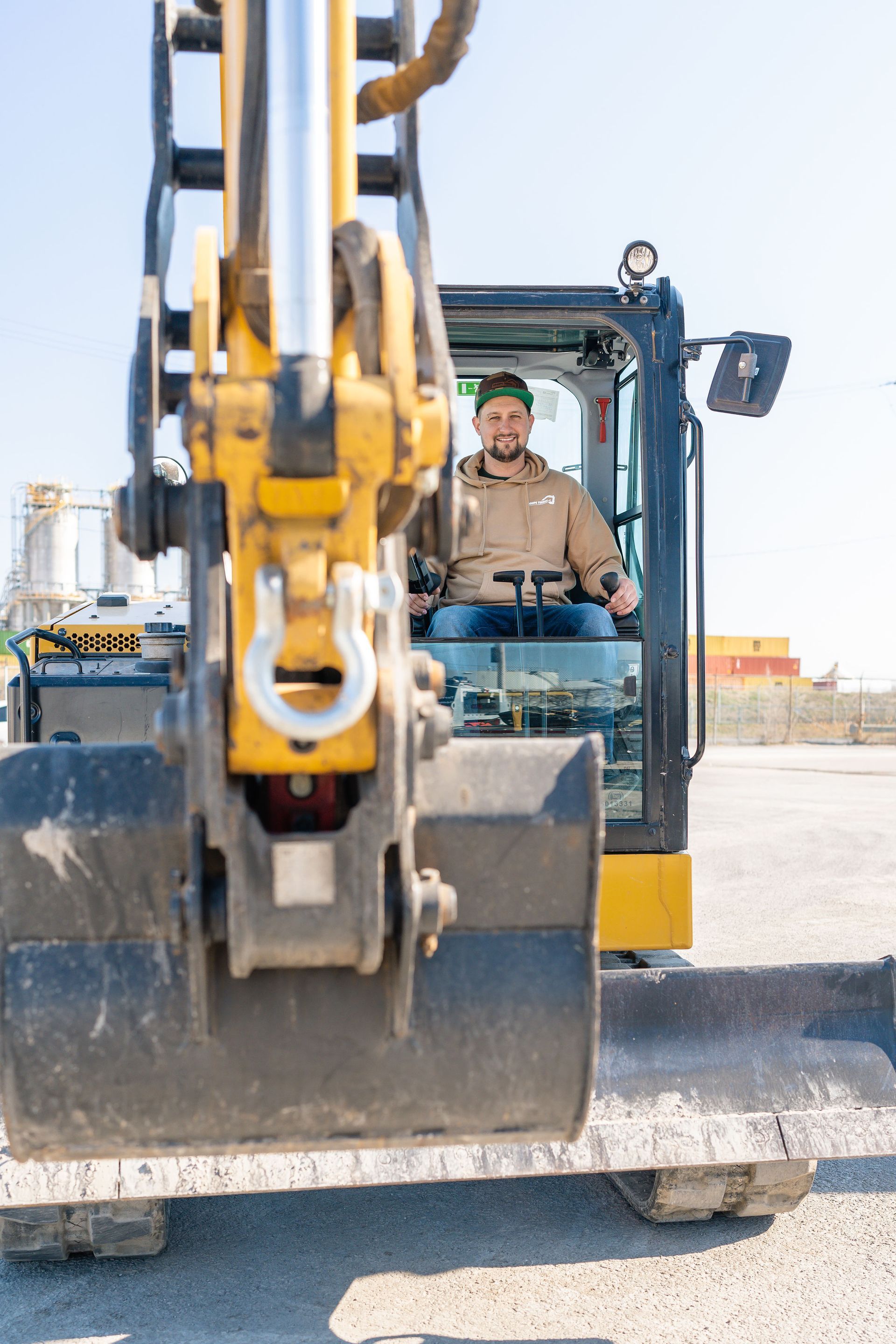 Un homme conduit une excavatrice sur un chantier de construction.