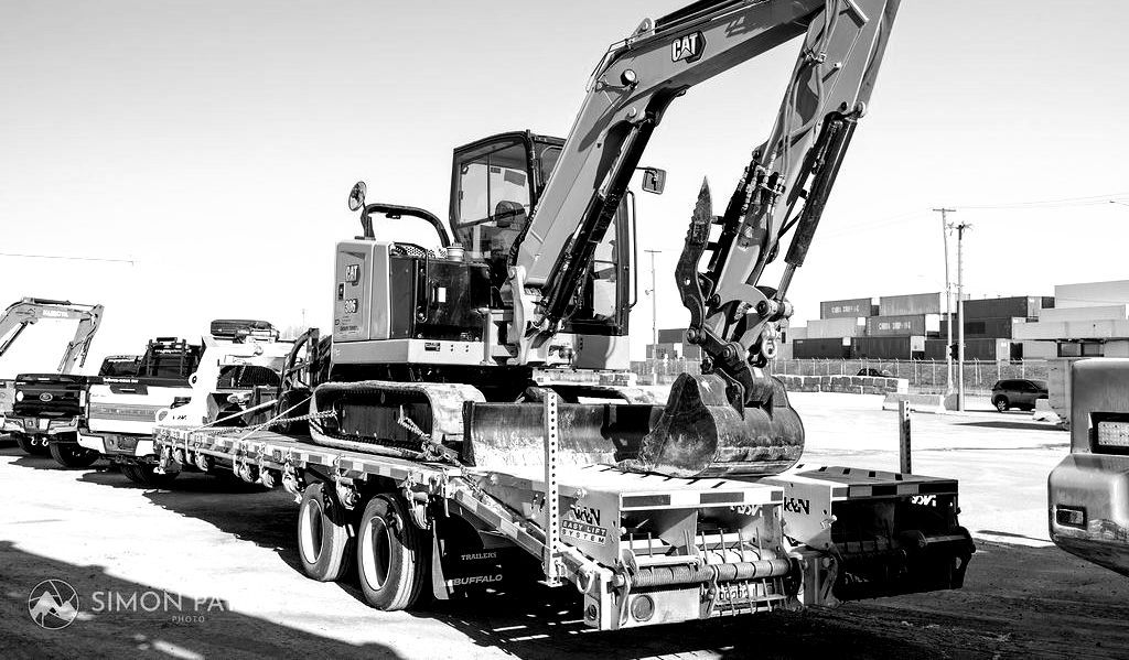 Une photo en noir et blanc d'une excavatrice sur une remorque