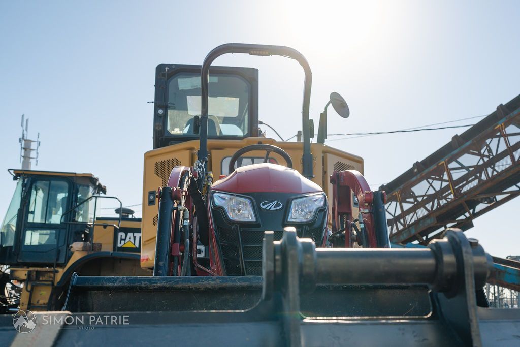Un bulldozer est garé à côté d'une grue sur un chantier de construction.
