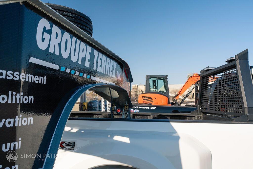 Un camion avec une barre de remorquage à l'arrière est garé dans un parking.