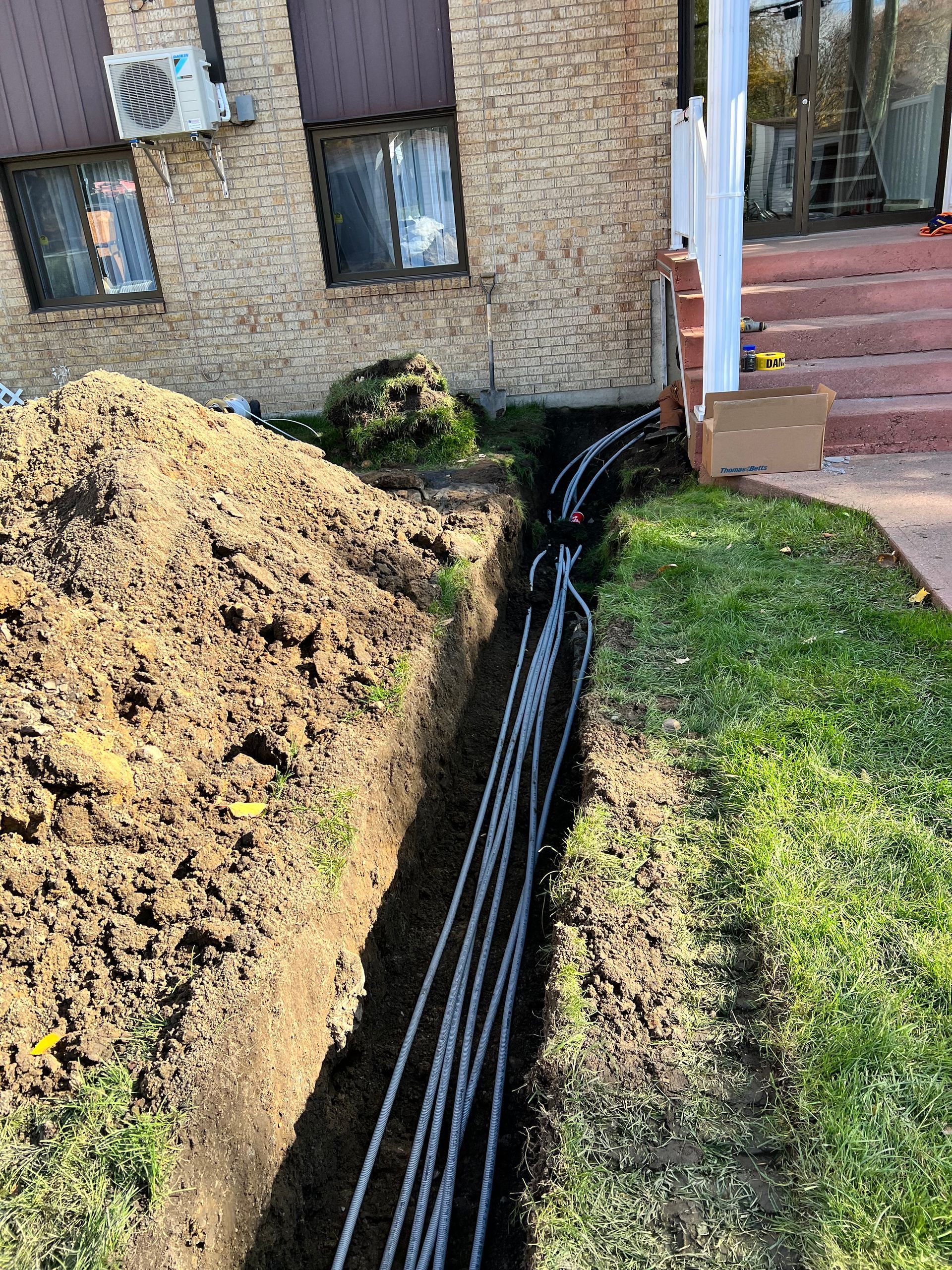 Un tas de fils sortent du sol devant une maison.