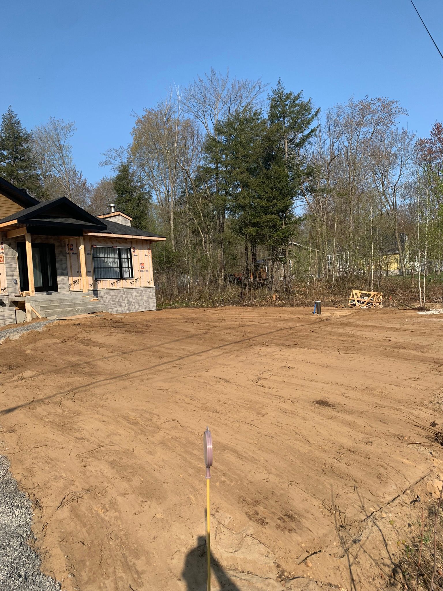 Une maison est en construction au milieu d'un champ de terre.