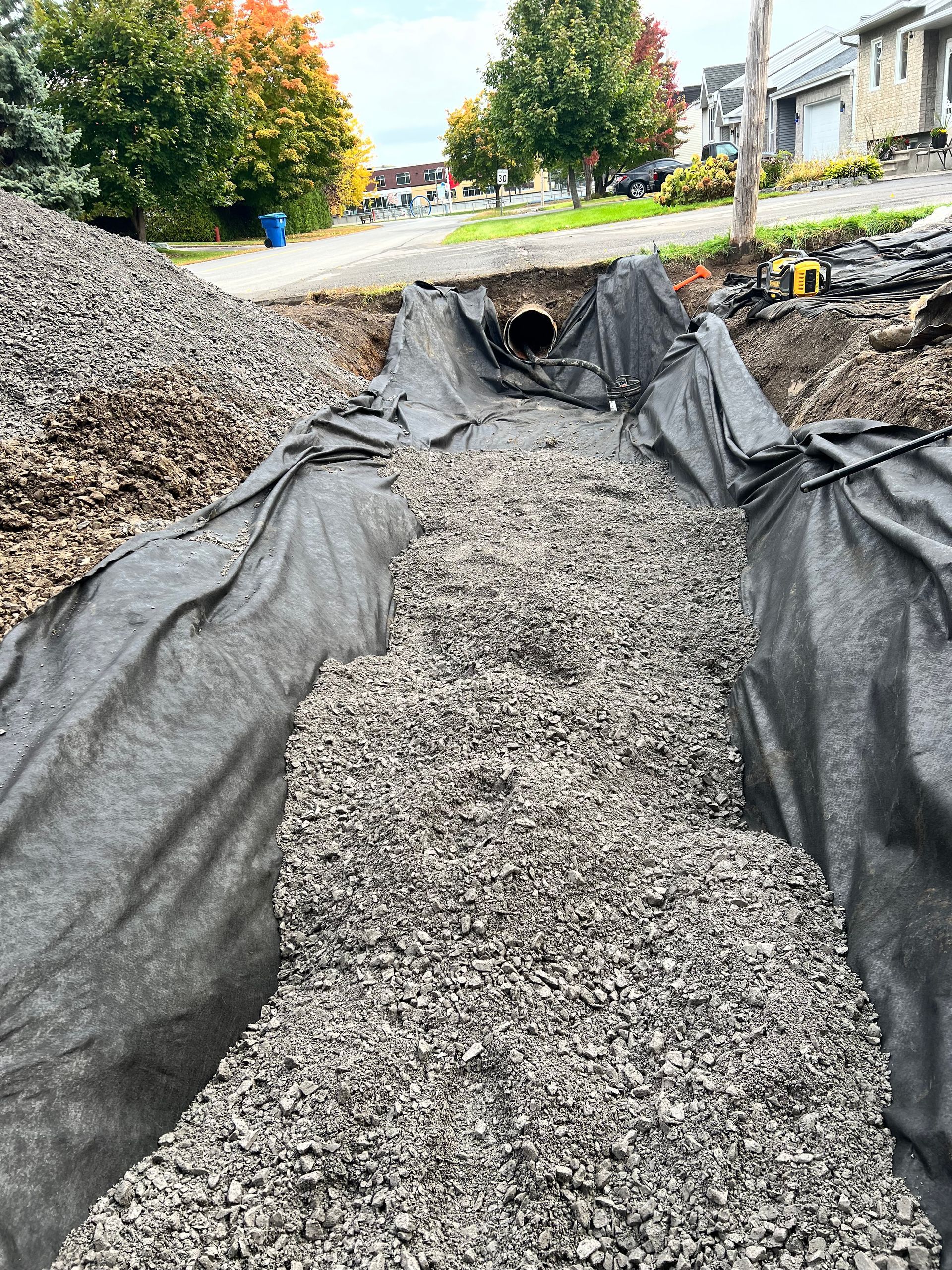 Un gros tas de gravier est recouvert d'une bâche noire.