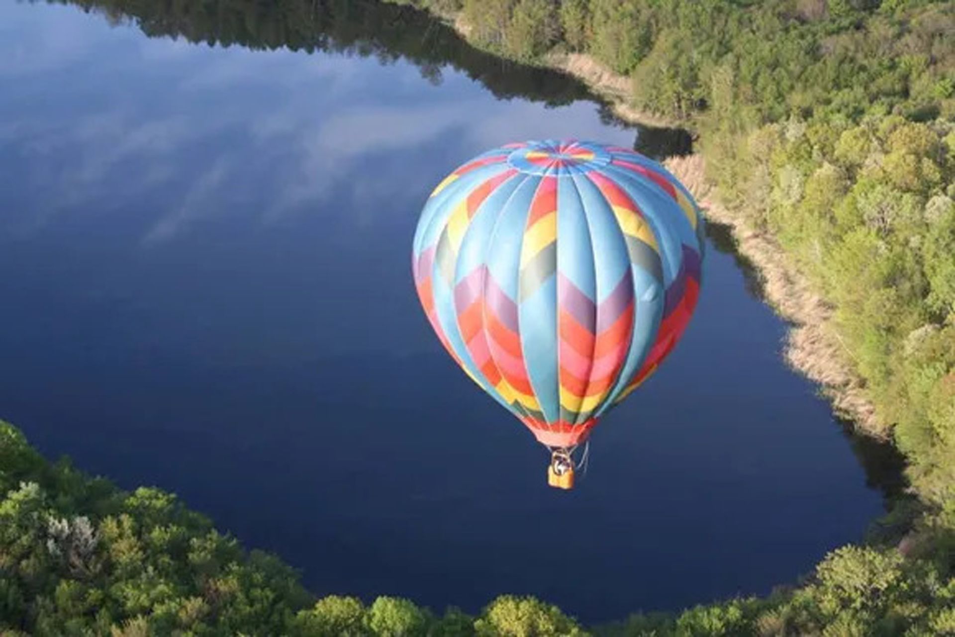 Hot Air Balloon Flying Over a Lake