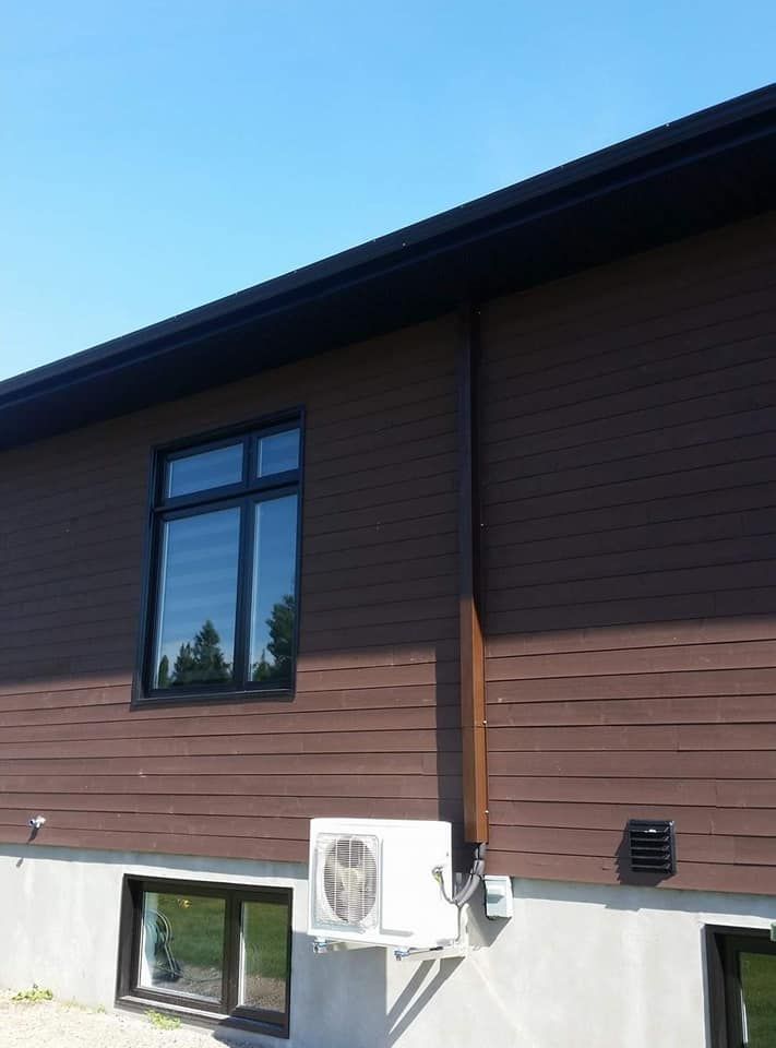 Une maison brune avec un climatiseur blanc sur le côté.