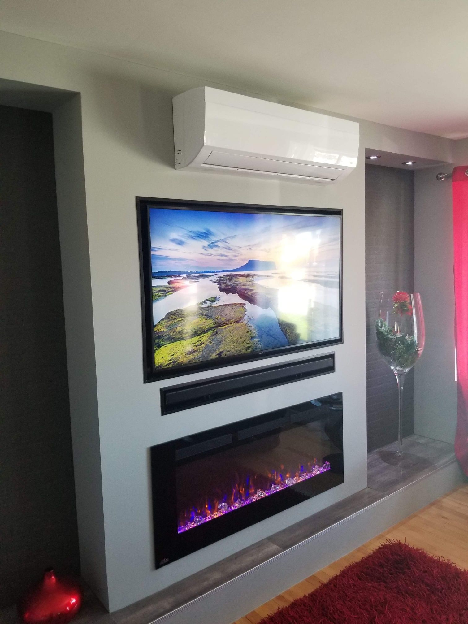 Un salon avec une cheminée et une télévision écran plat au mur.