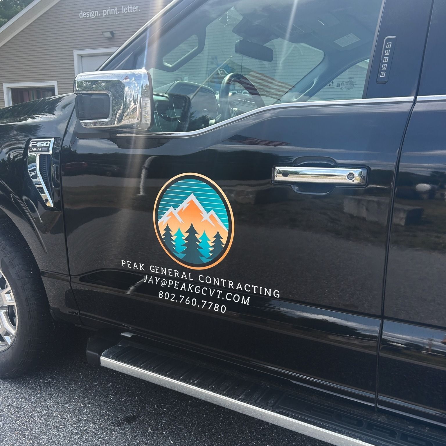 Black truck with Peak General Contracting logo on the door. Website and phone number listed below.