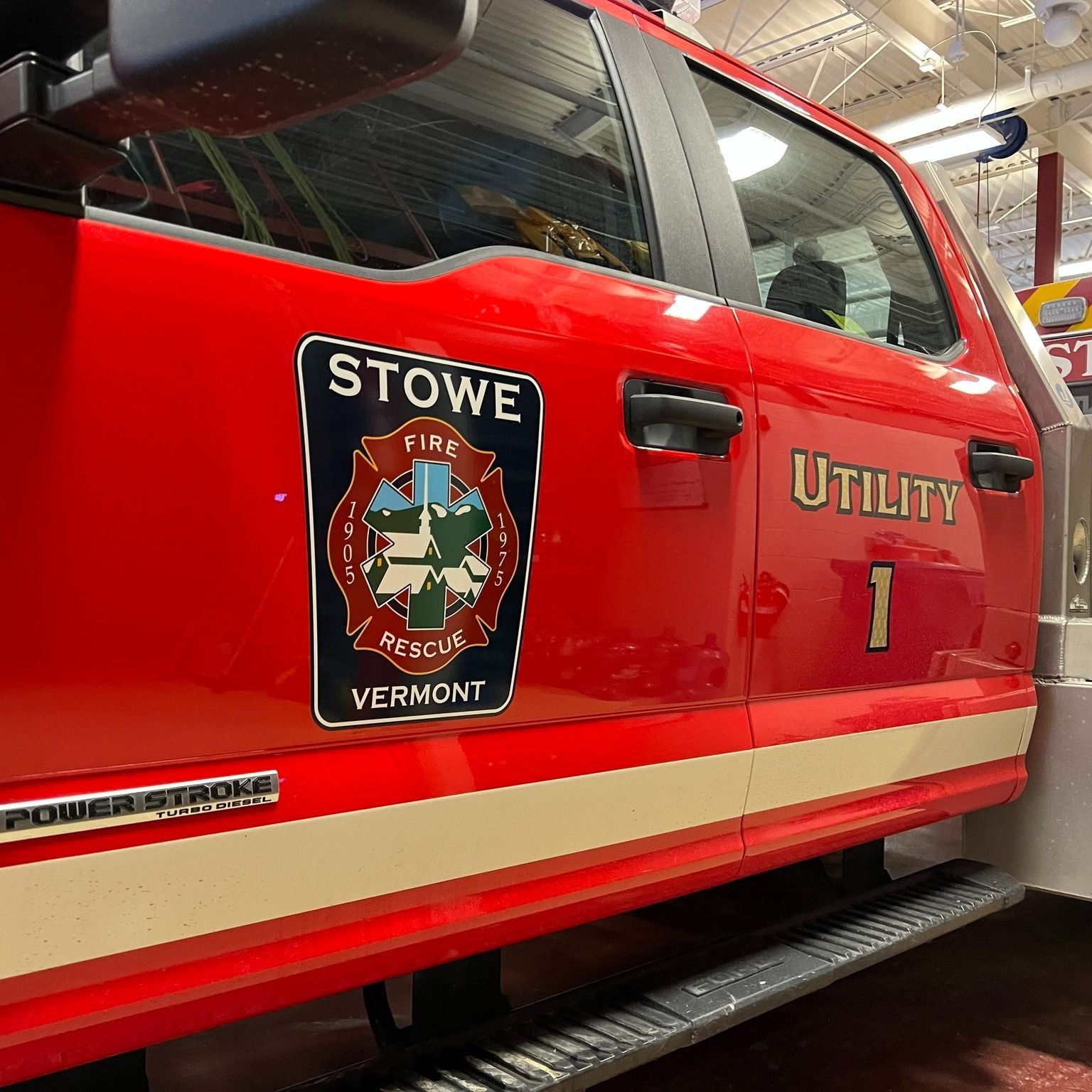 Red Stowe Fire Rescue utility truck with logo on door.