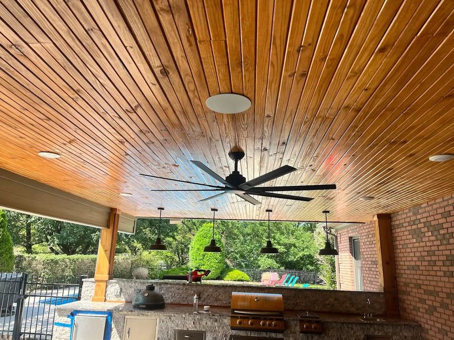 A wooden ceiling with a ceiling fan hanging from it.
