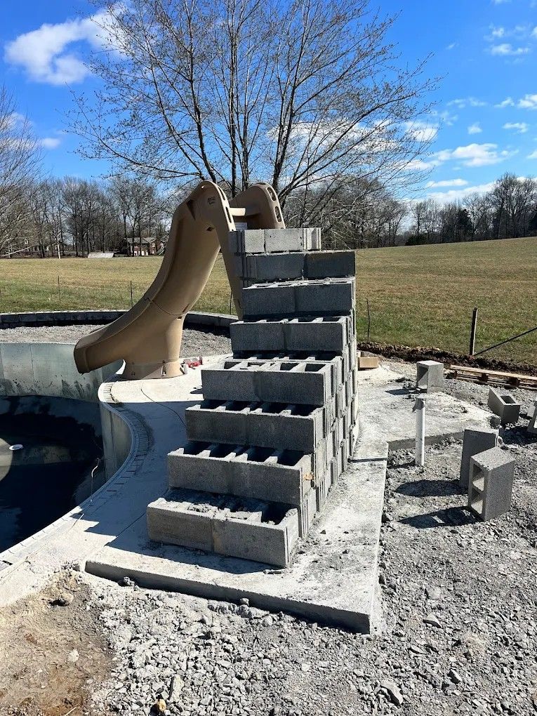 A slide is being built next to a pile of bricks.