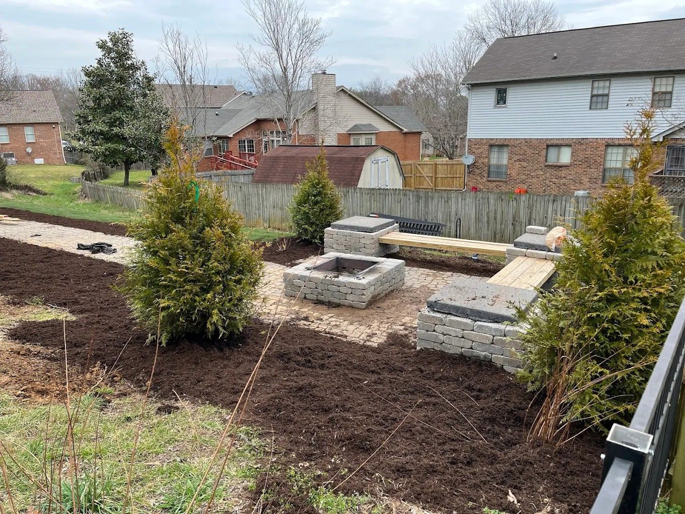 A fire pit is being built in the backyard of a house.