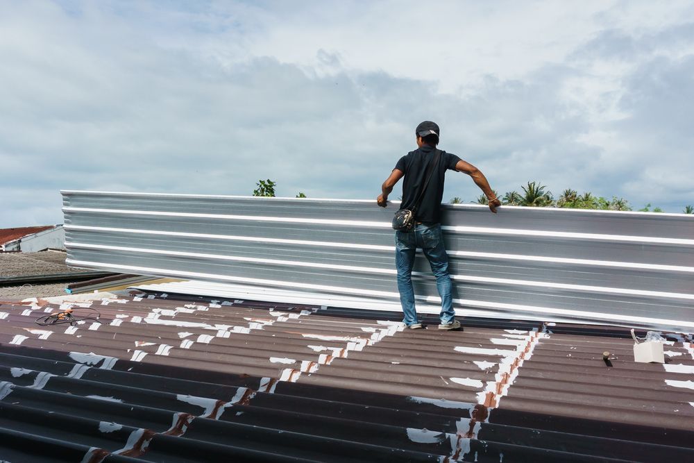 Man installing steel sheet — We Supply Sheet Metal in the Southern Highlands, NSW