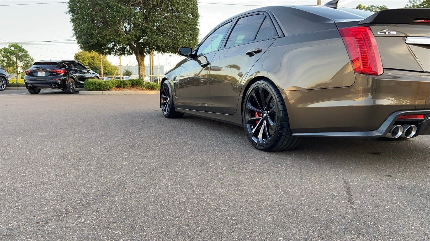 A car is parked on the side of the road in a parking lot.
