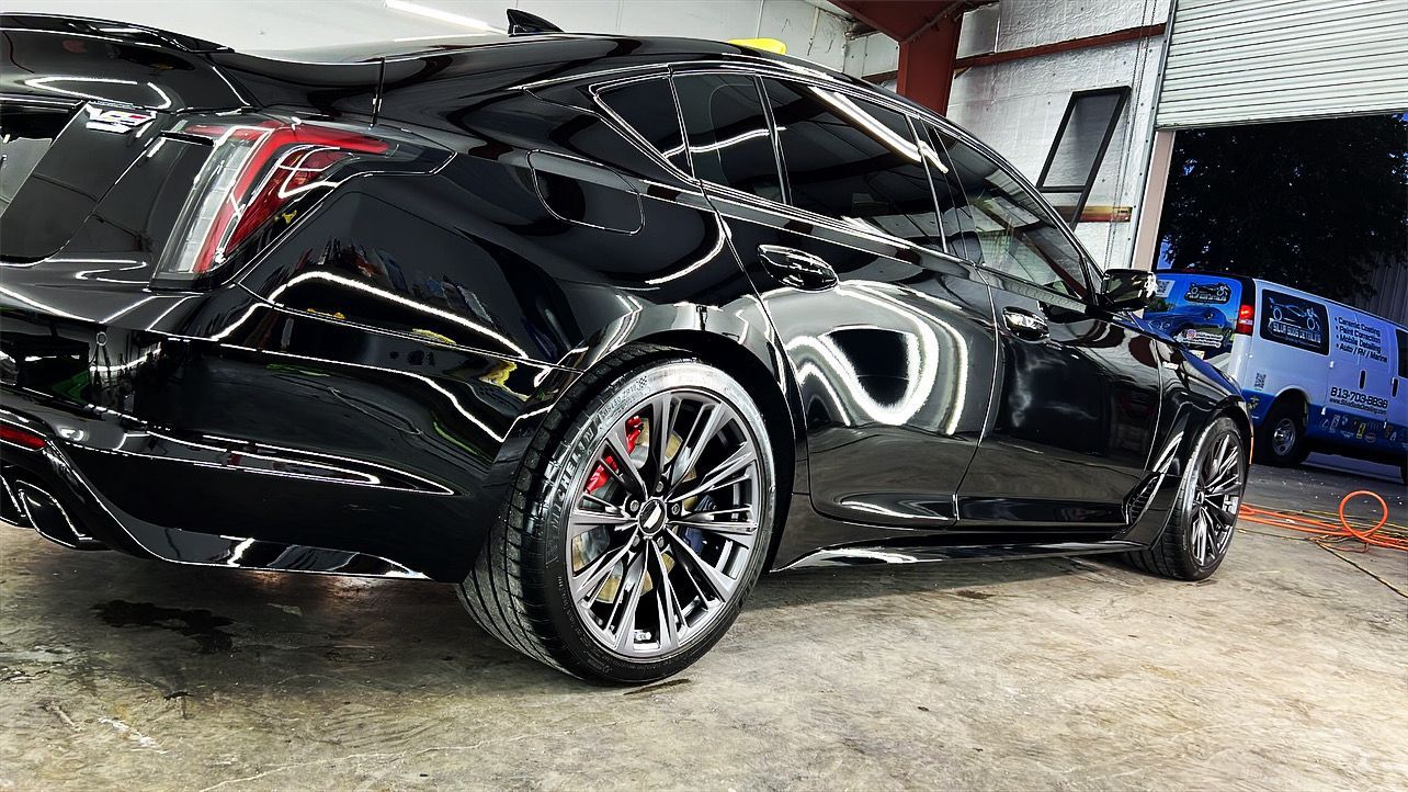 A black car is parked in a garage.