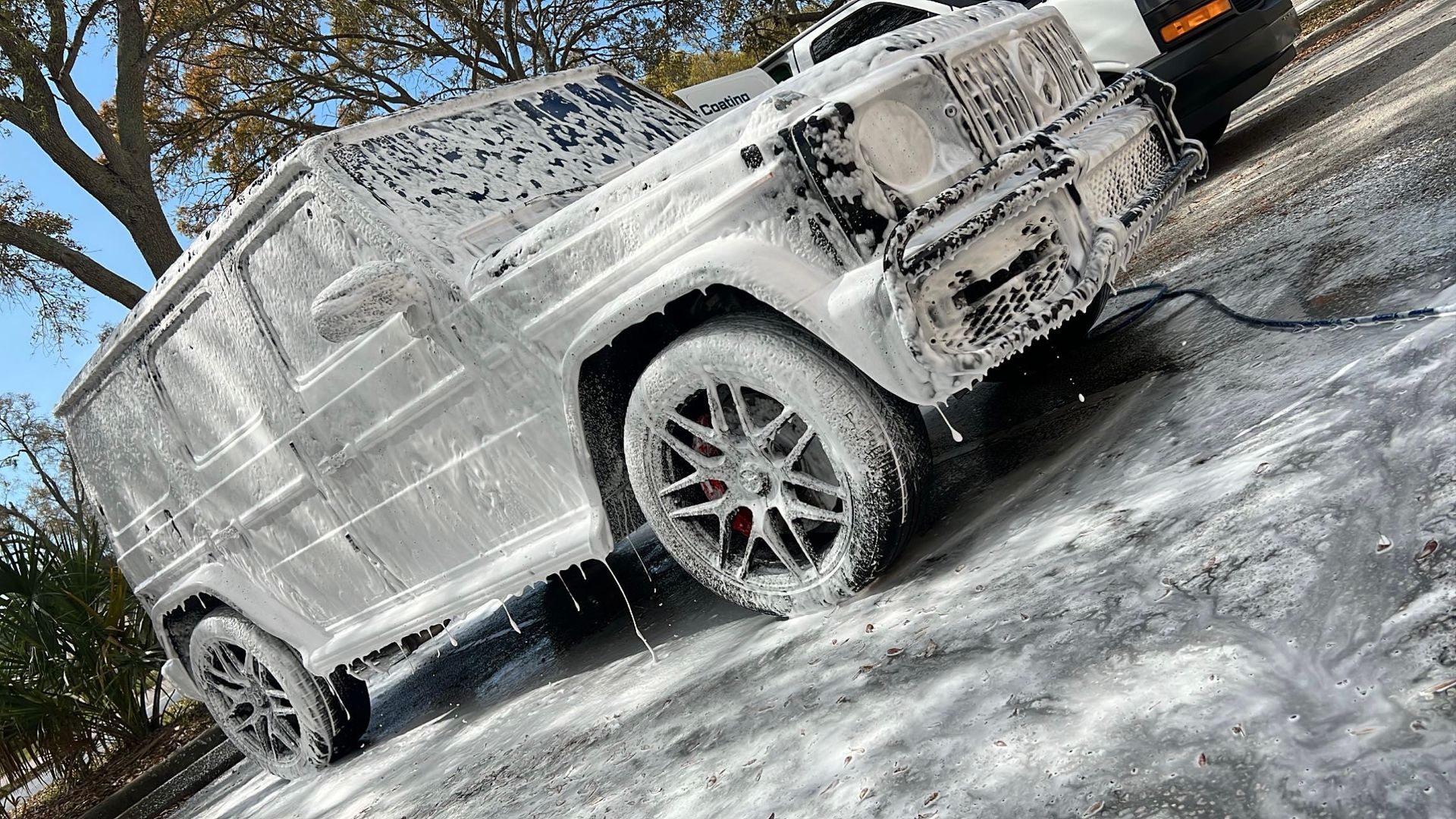 A jeep is covered in foam on the side of the road.