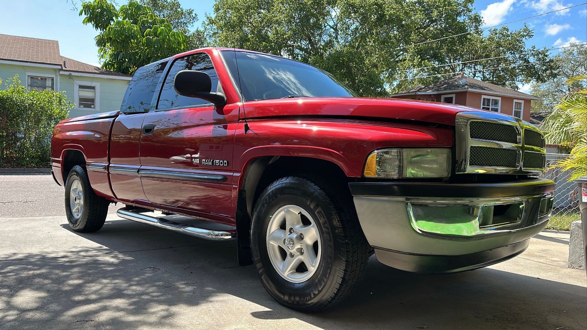 A red dodge ram truck is parked in a driveway in front of a house.