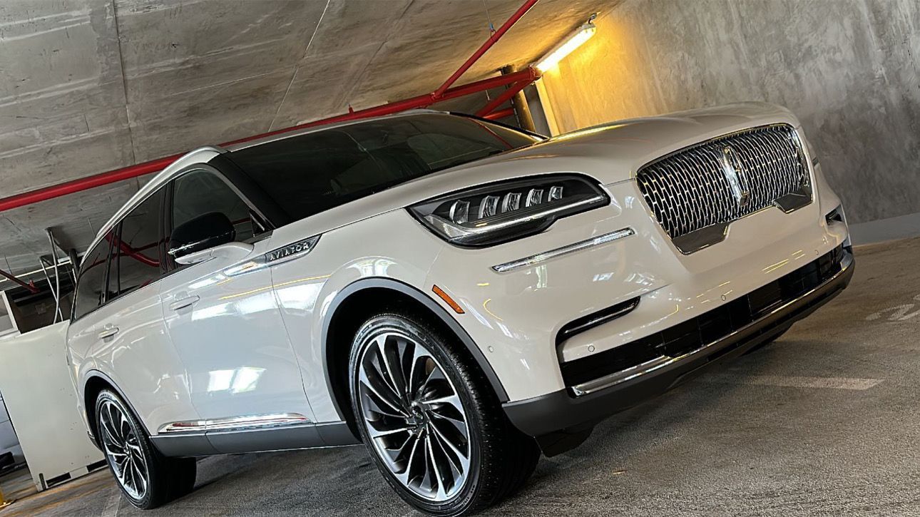 A white lincoln aviator is parked in a garage.