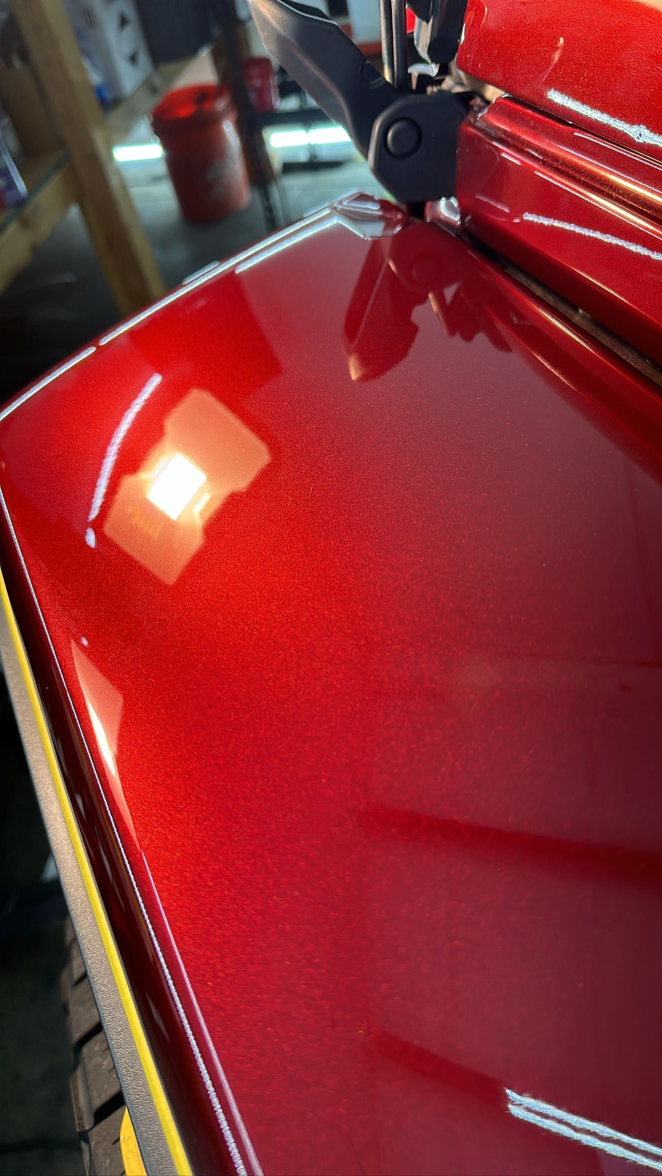 A close up of a red car with a yellow stripe on the side