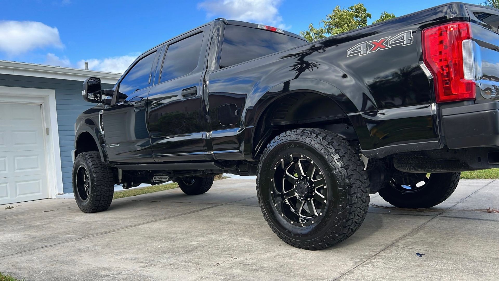 A black pickup truck is parked in front of a garage.