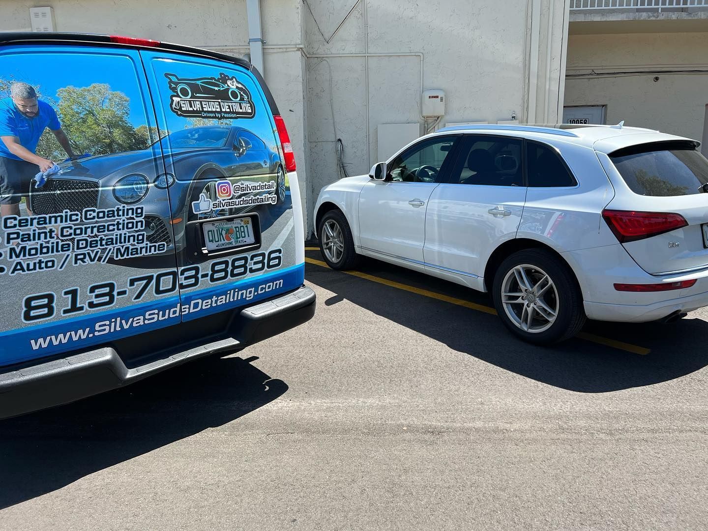 Two cars are parked next to each other in a parking lot.