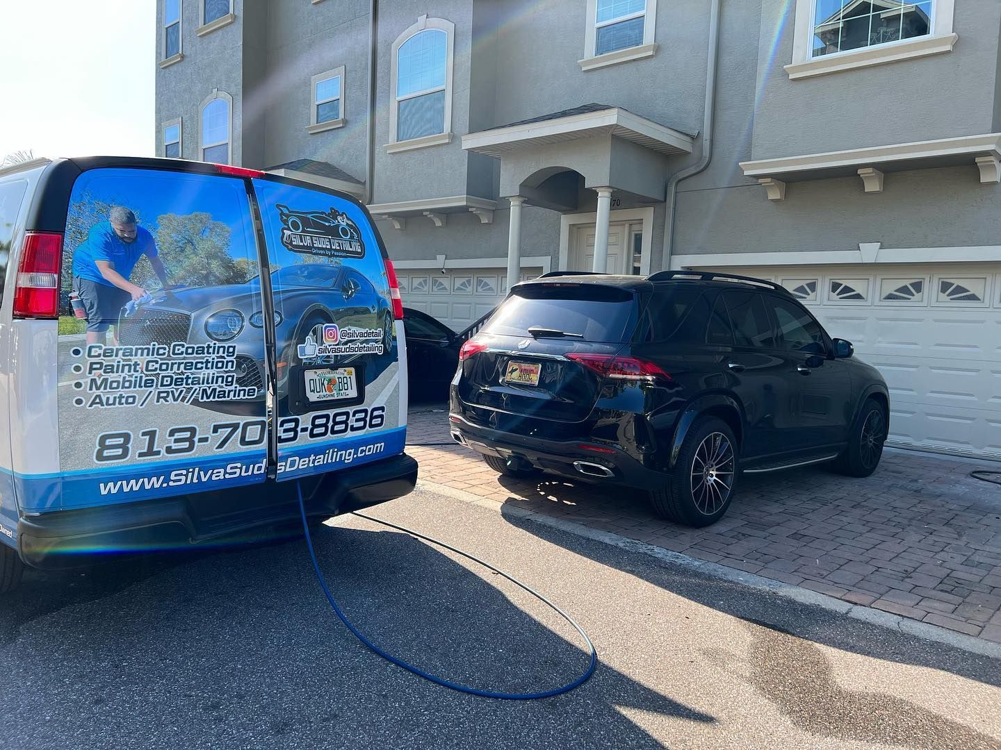 A van is parked in front of a building next to a car.
