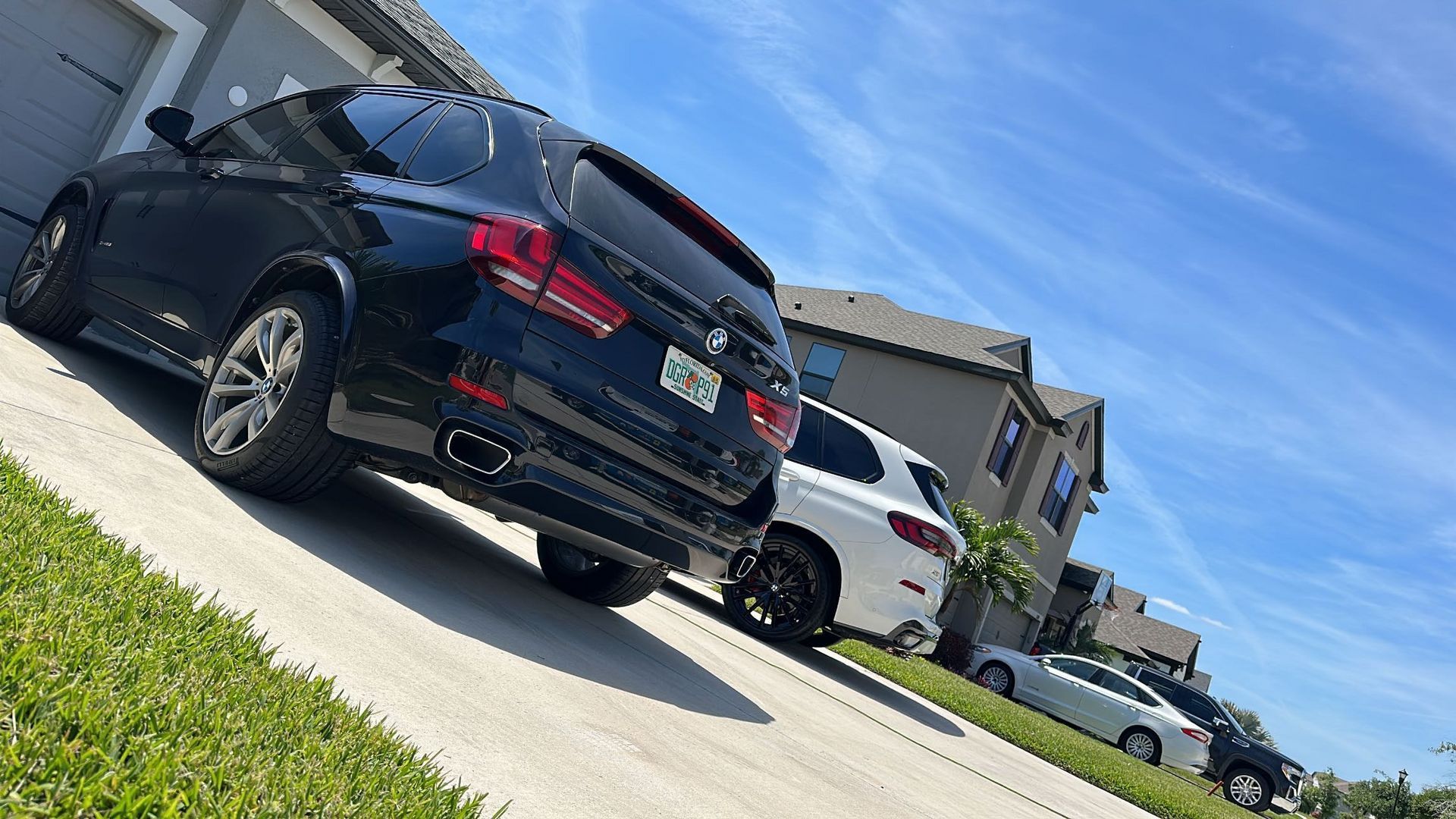 A black car is parked on the side of the road next to a white car.