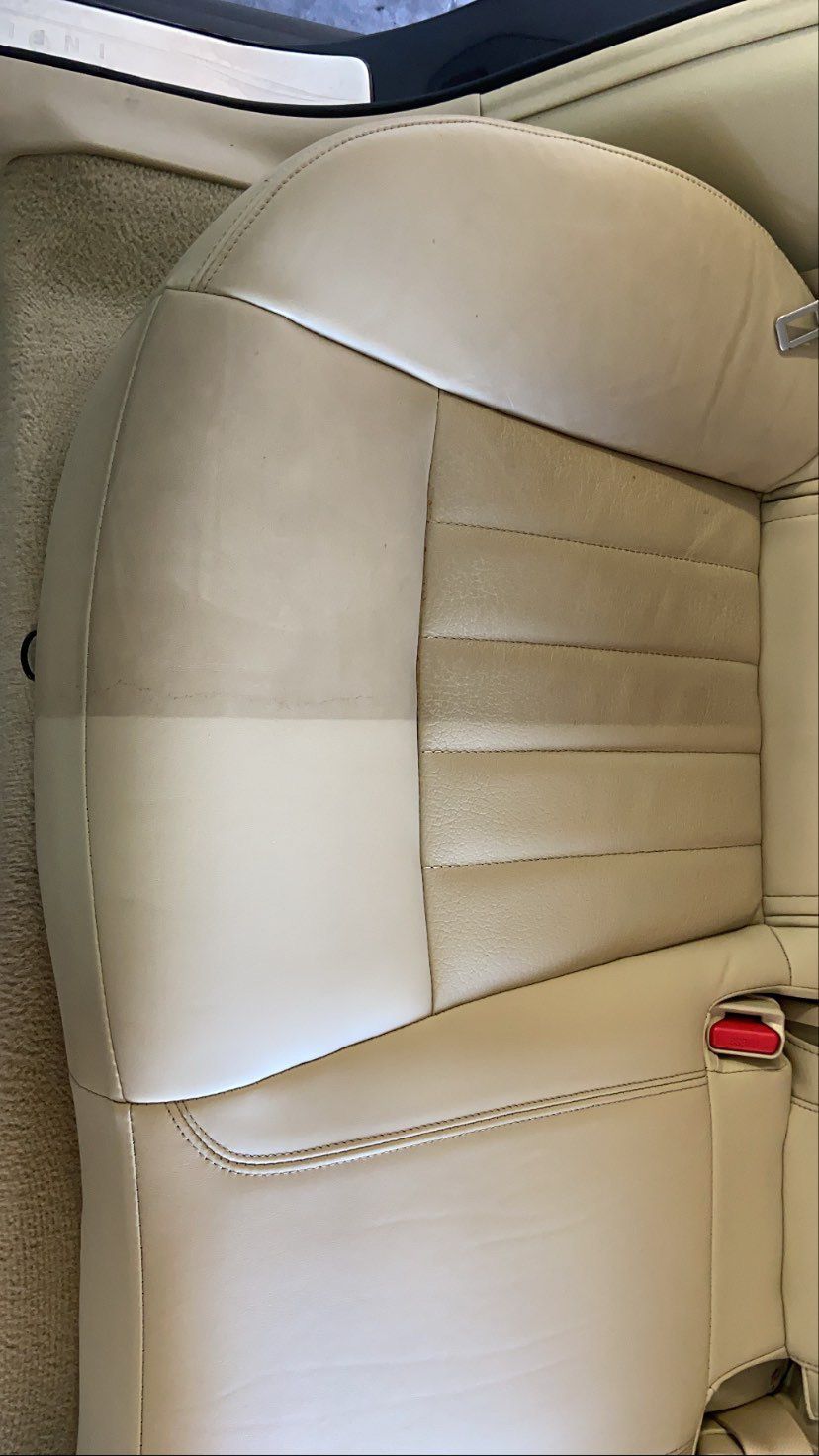 A close up of a tan leather seat in a car.