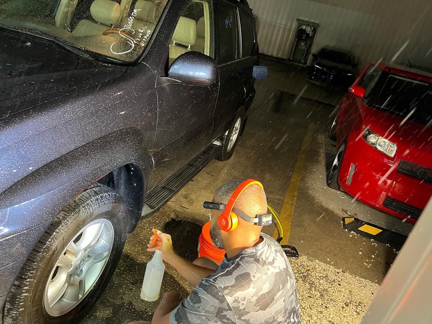 A man is cleaning a car with a spray bottle.