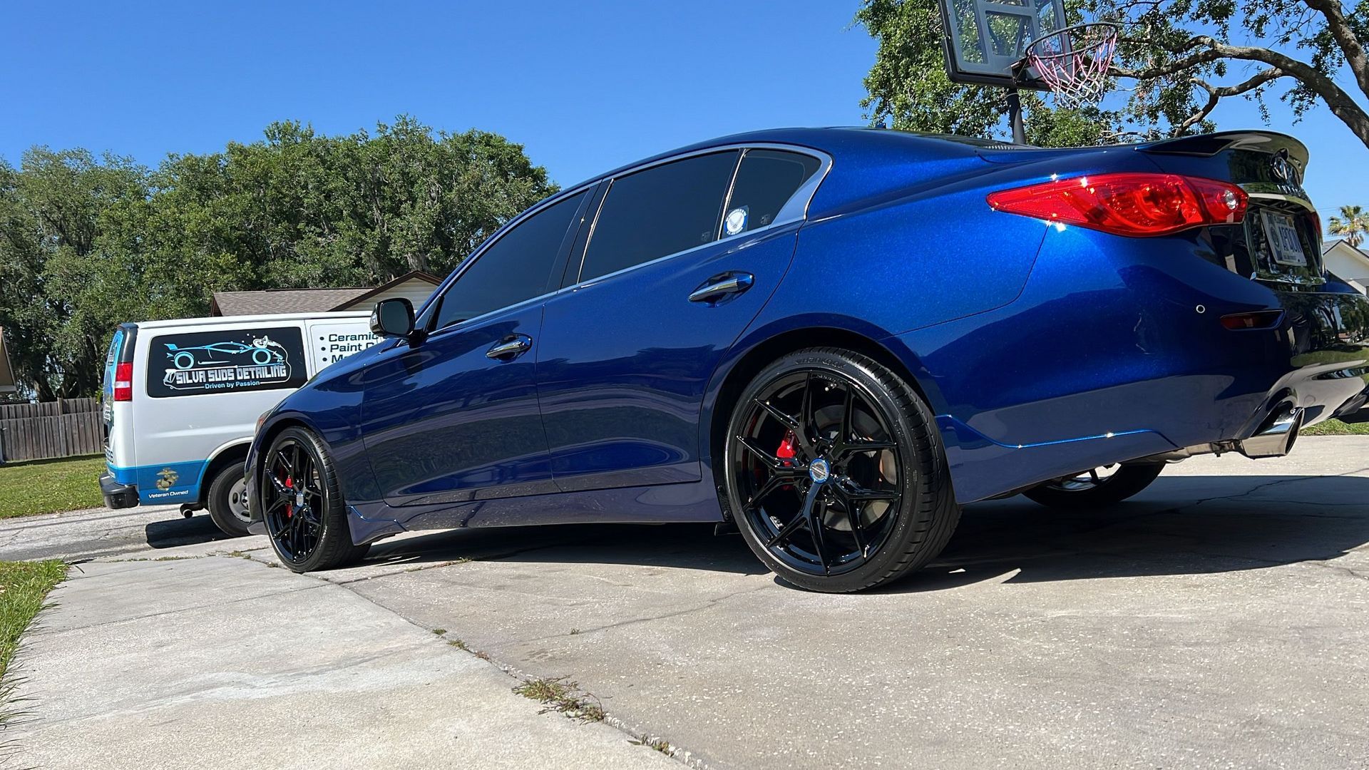 A blue car is parked on the side of the road.
