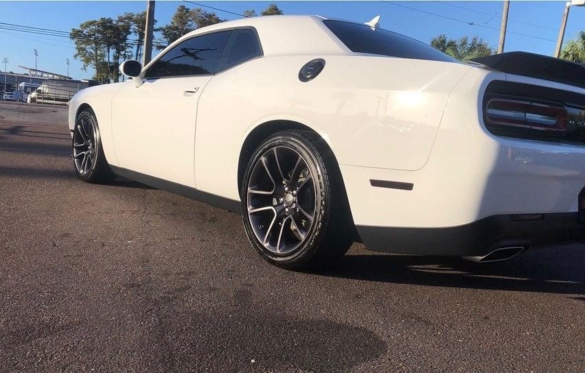 A white dodge challenger is parked on the side of the road.