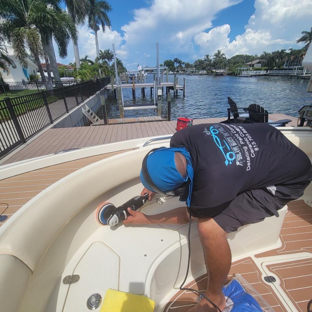 A man is polishing a boat with a machine.