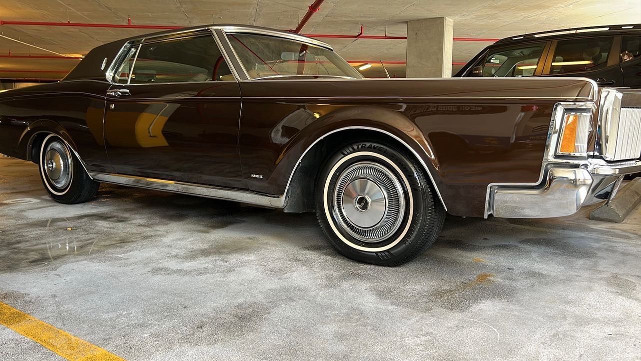 A brown lincoln continental is parked in a parking garage.