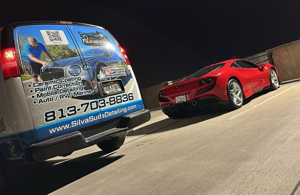 A van is parked next to a red sports car.