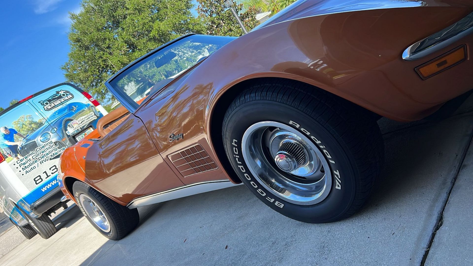 A brown corvette is parked on the side of the road.