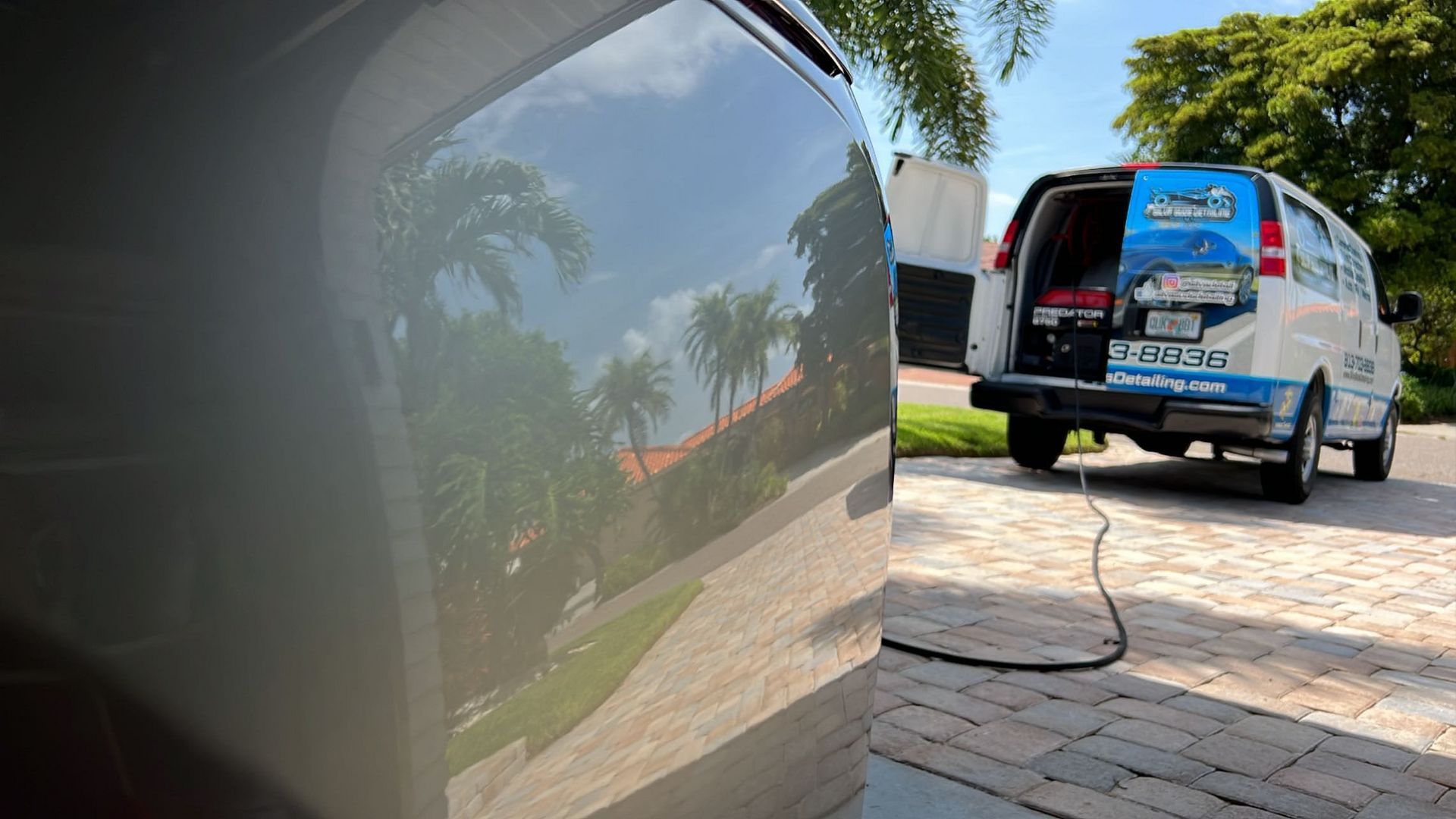 A van is parked in a driveway with the back door open.