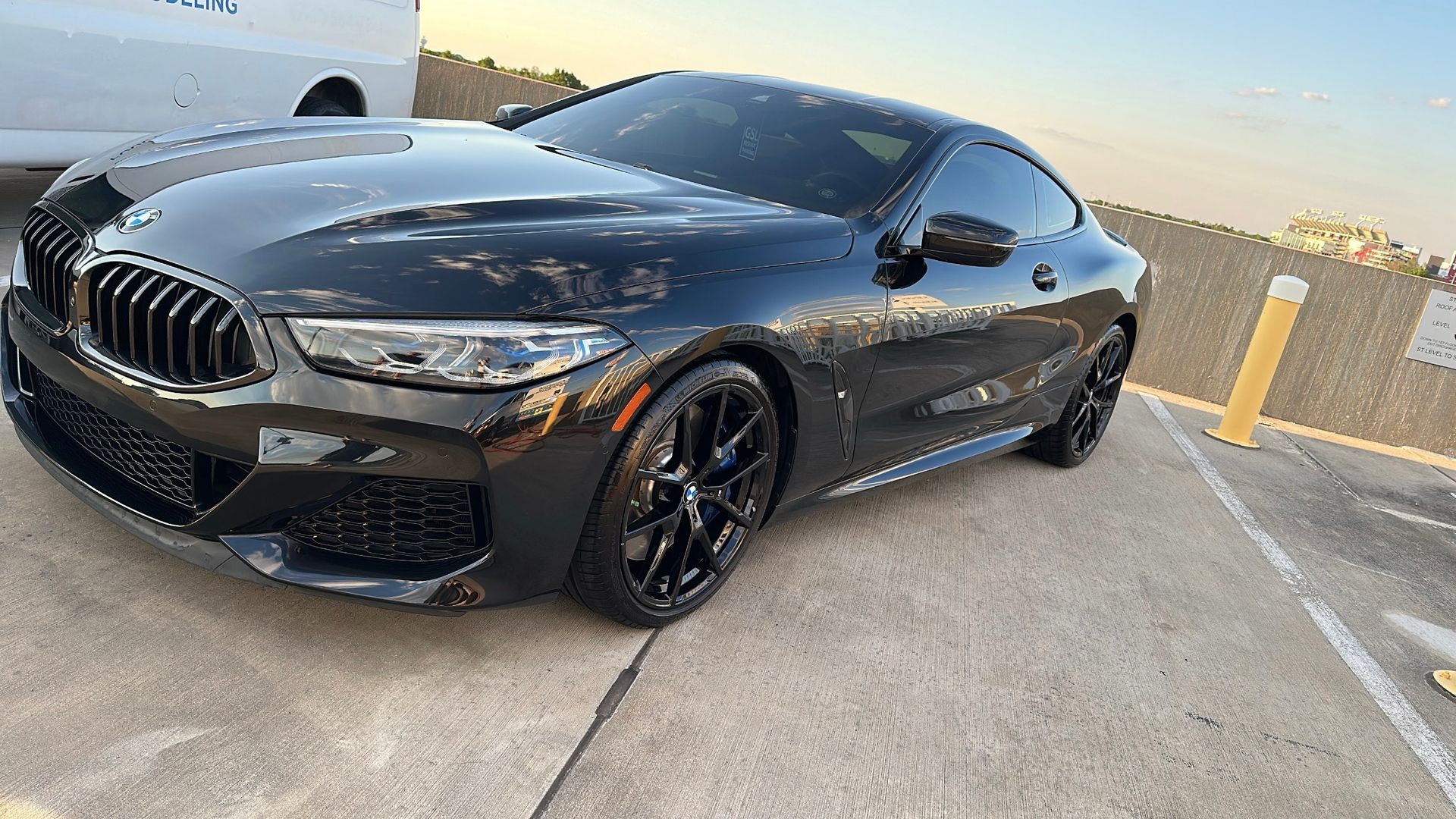 A black bmw 8 series coupe is parked in a parking lot.