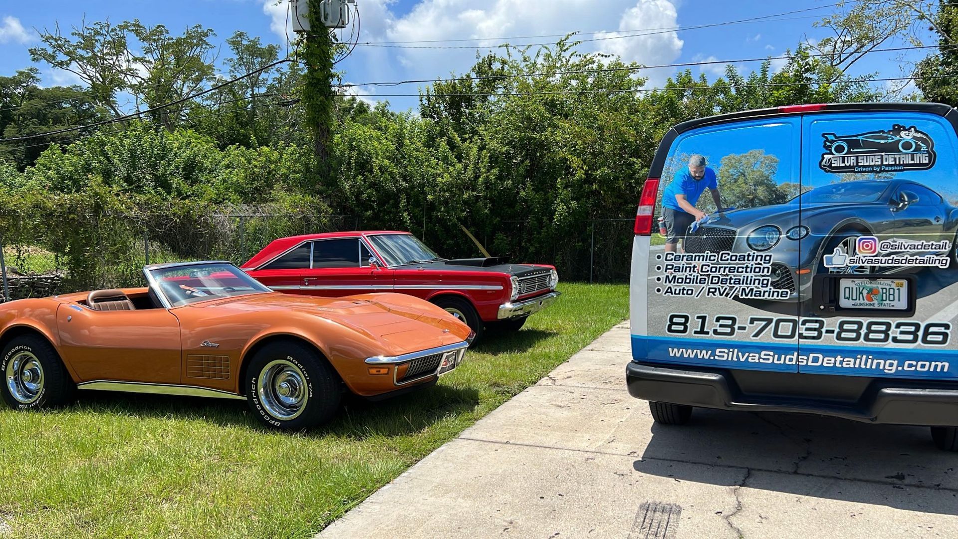 Three old cars are parked next to a van.