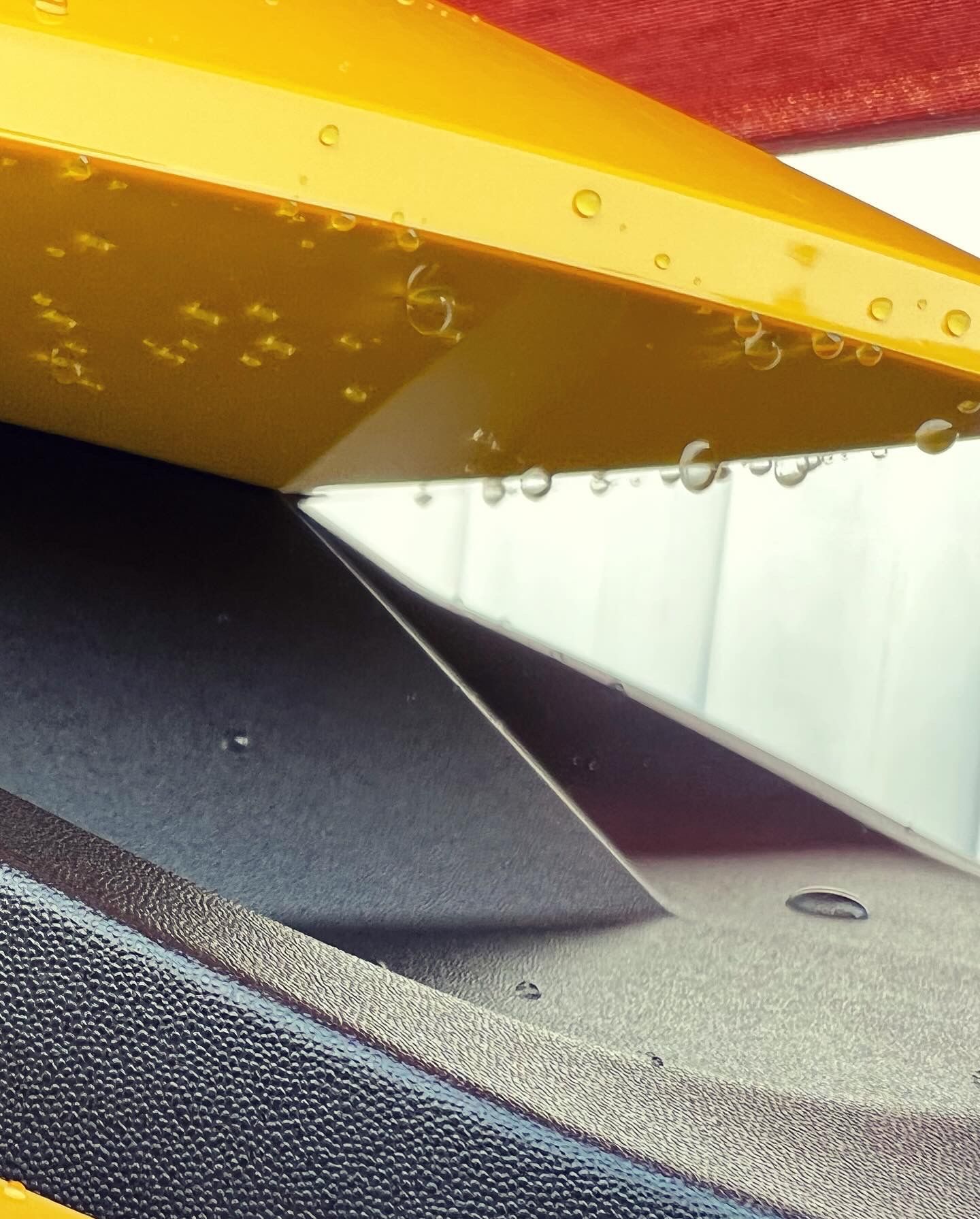 A close up of a yellow object with water drops on it