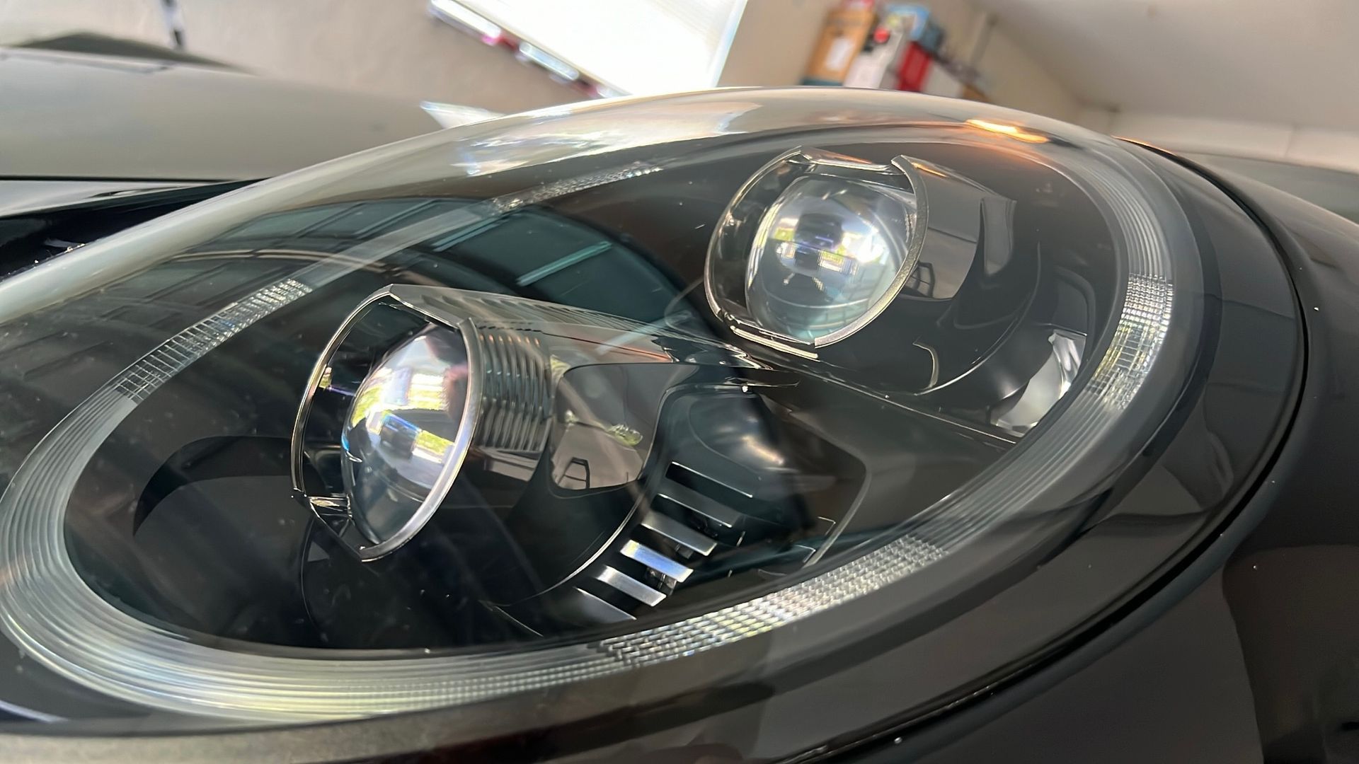 A close up of a car 's headlight in a garage.
