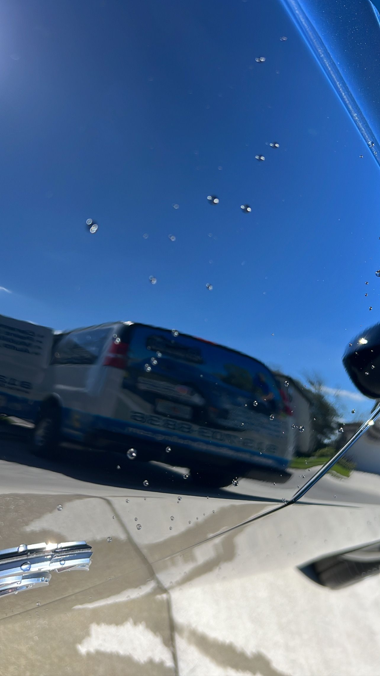 A car is parked on the side of the road on a sunny day.