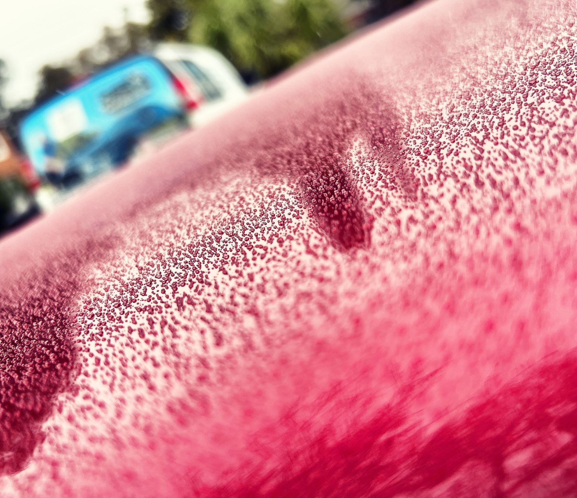 A close up of a pink car with a lot of small dots on it.